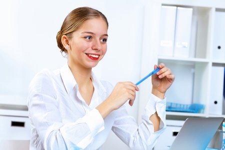 Young pretty woman in business wear working in officeの写真素材
