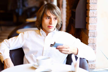Portrait of young handsome man sitting in restaurantの写真素材