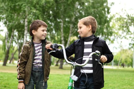 Happy smiling boy on a bicycle in the green parkの写真素材