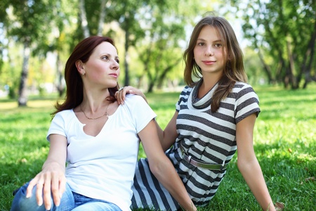 Mother with her daughter together in green summer parkの写真素材