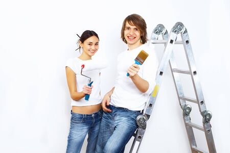Young couple with paint brushes doing renovation togetherの写真素材