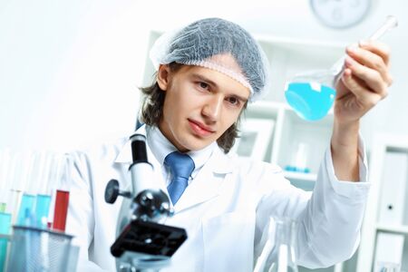 Young scientist in white uniform working in laboratoryの写真素材