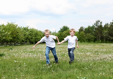two twin brothers outdoors on the grassの写真素材