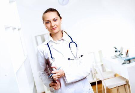 Friendly young female doctor in uniform in medical officeの写真素材