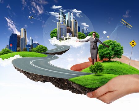 Collage with a human hand holding a green landscapeの写真素材
