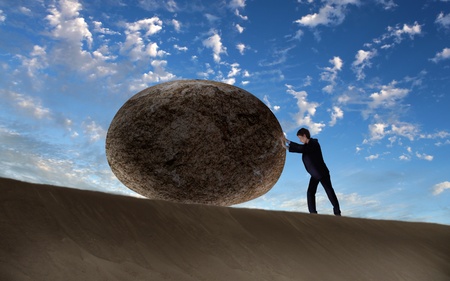 Image of businessman rolling a giant stoneの写真素材