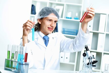 Young scientist in white uniform working in laboratoryの写真素材