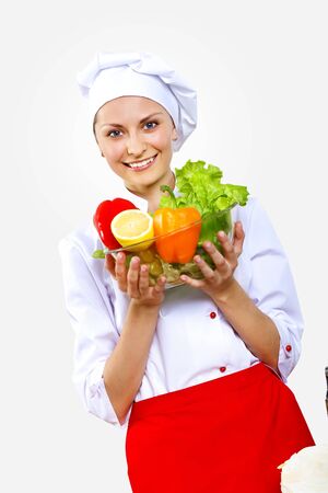 Portrait of a young cook in uniform preparing mealの写真素材