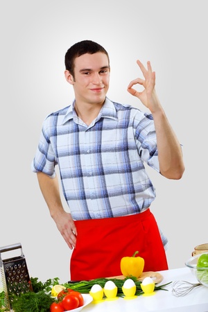 Young husband wearing apron at home cooking mealの写真素材