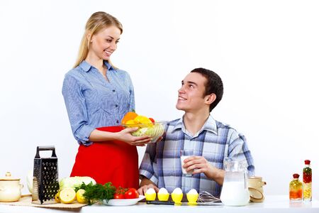 Happy husband and wife cooking together at homeの写真素材