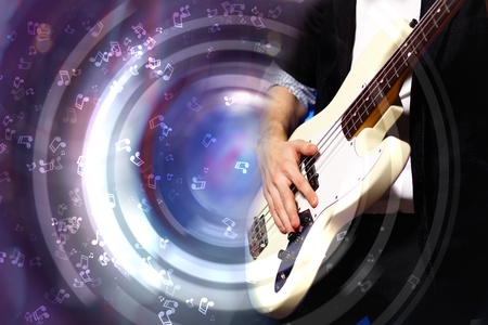 Young guitar player with instrument performing in night clubの写真素材