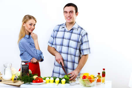 Young husband and wife together coooking at homeの写真素材
