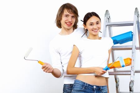 Young couple with paint brushes doing renovation togetherの写真素材