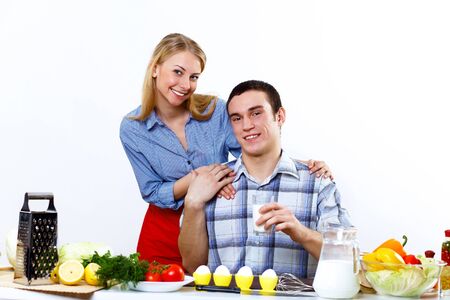 Happy husband and wife cooking together at homeの写真素材