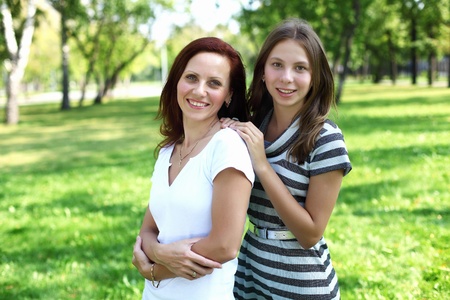 Mother with her daughter together in green summer parkの写真素材