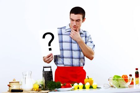 Young husband wearing apron at home cooking mealの写真素材