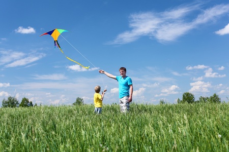 father with son in summer playing with kiteの写真素材