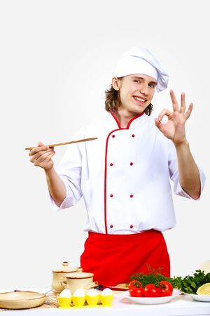 Portrait of a young cook in uniform preparing mealの写真素材