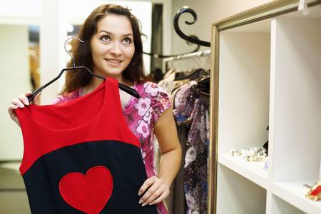 Young woman doing shopping and choosing clothesの写真素材