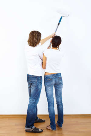 Young couple with paint brushes doing renovation togetherの写真素材