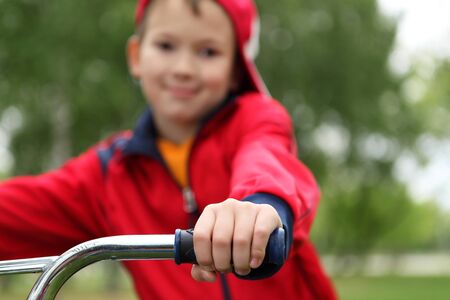 Happy smiling boy on a bicycle in the green parkの写真素材
