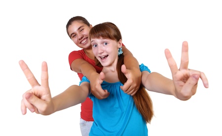 two teenage girls together in studio against white backgroundの写真素材