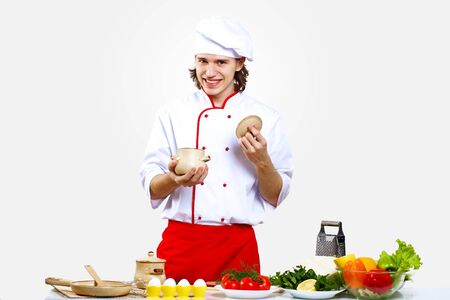 Portrait of a young cook in uniform preparing mealの写真素材
