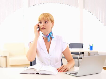 Portrait of young business woman sitting at the table の写真素材