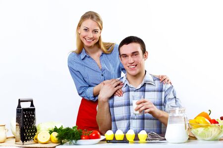 Happy husband and wife cooking together at homeの写真素材