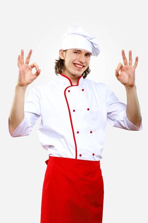 Portrait of a young cook in uniform preparing mealの写真素材