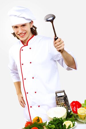 Portrait of a young cook in uniform preparing mealの写真素材