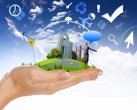 Collage with a human hand holding a green landscapeの写真素材