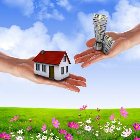 human hands holding model of a house against nature backgroundの写真素材