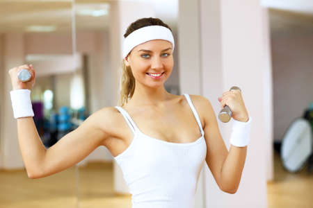 Young woman in sport wear doing sport in gymの写真素材