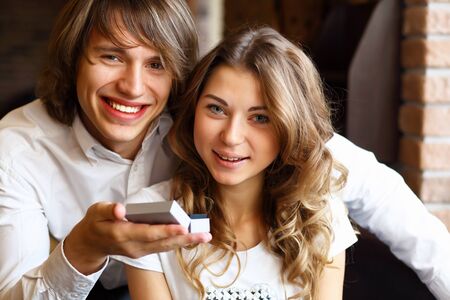 Young couple with a ring during an engagement in a restaurantの写真素材