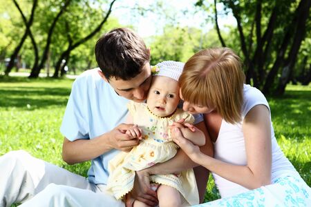 Young family with baby daughter together in the parkの写真素材