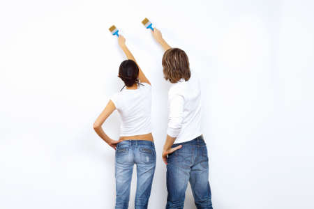 Young couple with paint brushes doing renovation togetherの写真素材
