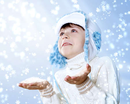 Portrait of little kid in winter wear against snow backgroundの写真素材