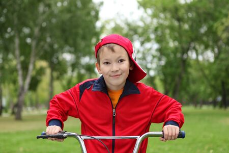 Happy smiling boy on a bicycle in the green parkの写真素材