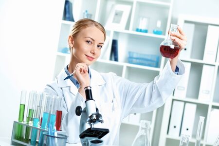 Young scientist in white uniform working in laboratoryの写真素材