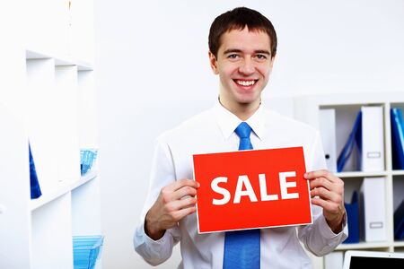 Young  businessman at work in office with sale signの写真素材