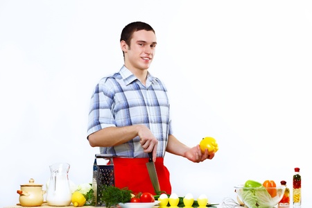 Young husband wearing apron at home cooking mealの写真素材