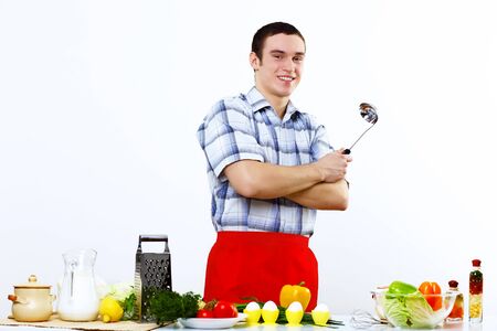 Young husband wearing apron at home cooking mealの写真素材