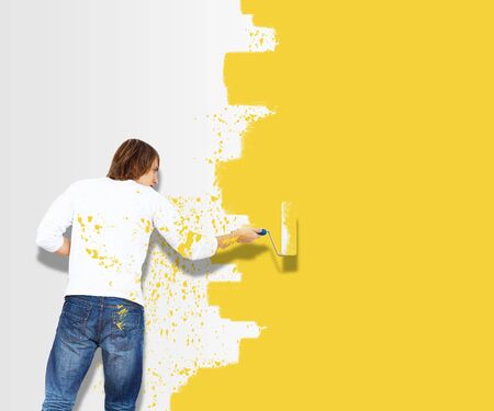 Young man with paint brush and wall with natural landscapeの写真素材