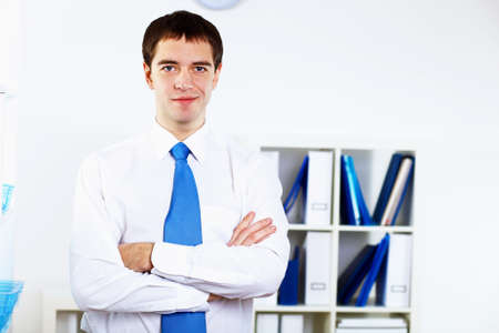 Young smiling happy businessman at work in officeの写真素材