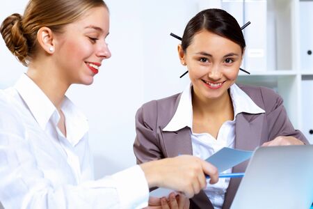 Young women in business wear working in office togetherの写真素材