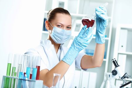Young scientist in white uniform working in laboratoryの写真素材