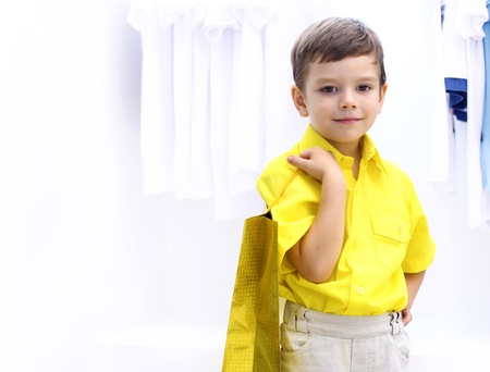 Little boy in yellow shirt doing shoppingの写真素材