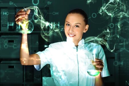 Young chemist in white uniform working in laboratoryの写真素材