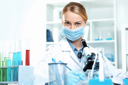 Young scientist in white uniform working in laboratory